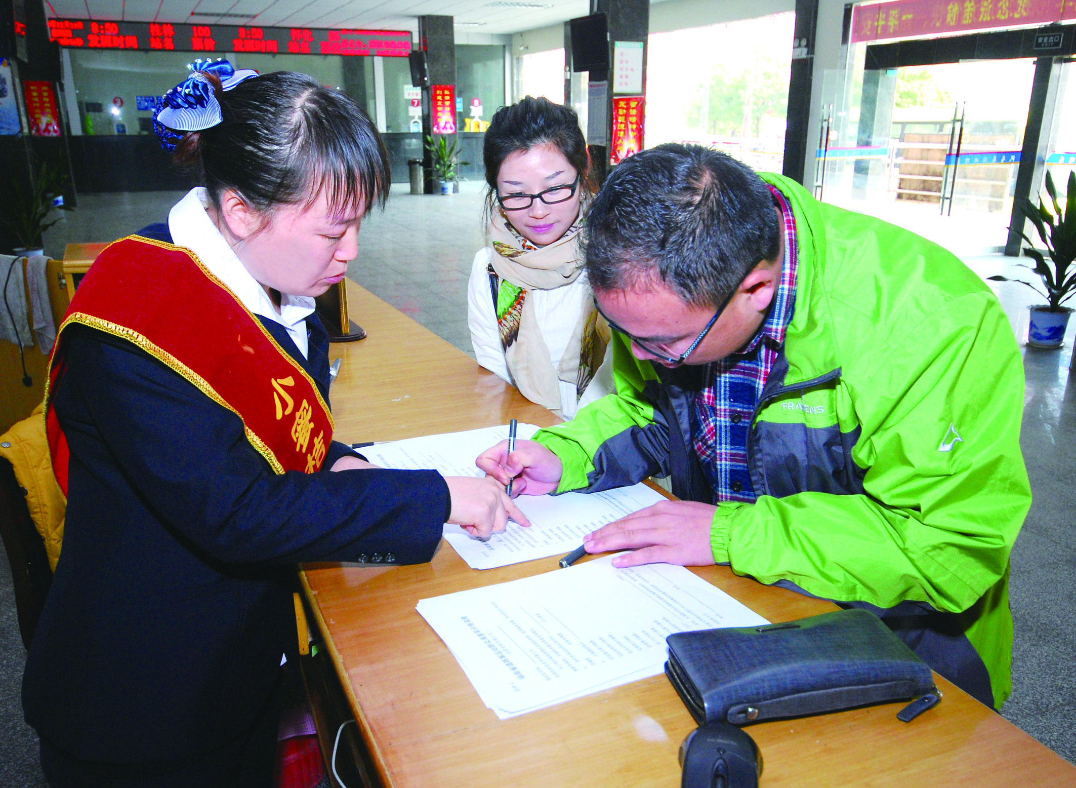 圖為洞口汽車總站站務(wù)人員在熱心為旅客服務(wù)。