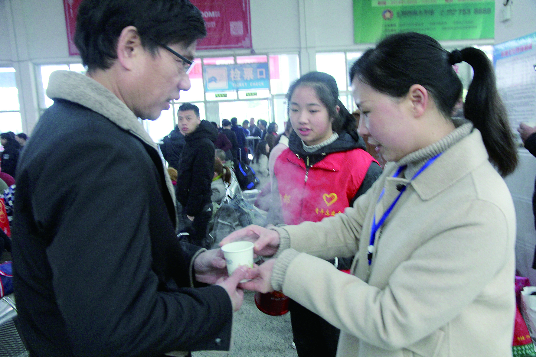 母女服務(wù)春運 2月13日，記者在新邵分公司汽車站看到，該分公司安全科副科長李喜梅與其在新邵一中初中部1701班就讀女兒劉嘉怡在車站擔(dān)當(dāng)志愿者。李喜梅在候車室耐心為旅客釋疑解惑，劉嘉怡為旅客遞上一杯杯熱茶，有時母女也相互合作，其樂融融。 祖冠 攝影報道